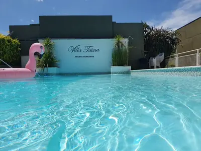 a swimming pool with a pink flamingo in front of a building at Aparts serranos in San Antonio de Arredondo