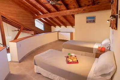 a room with two beds and a staircase at Casa Arboles De Tala con parque amplio in Villa General Belgrano