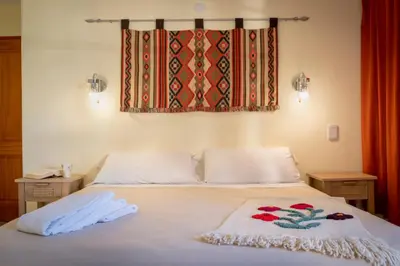 a bedroom with a bed with two towels on it at Casa Arboles De Tala con parque amplio in Villa General Belgrano