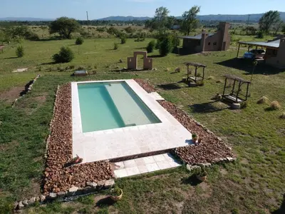 an overhead view of a swimming pool in a field at Pequeña Polonia-Lodge & Cabañas in Los Reartes