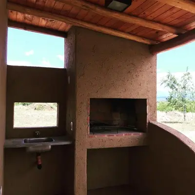 a fireplace in a room with two windows at Pequeña Polonia-Lodge & Cabañas in Los Reartes