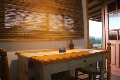 a table in a room with a window with a window blind at Pequeña Polonia-Lodge & Cabañas in Los Reartes