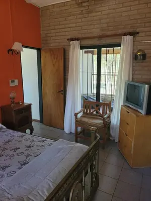 a bedroom with a bed and a tv and a chair at Casona de campo in Santa María