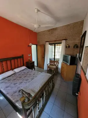 a bedroom with a large bed and a tv at Casona de campo in Santa María