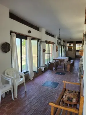 a living room with a table and chairs and windows at Casona de campo in Santa María