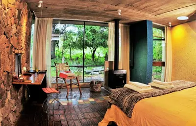 a bedroom with a bed and a desk and a window at Cuatrovientos Hostería in San Javier