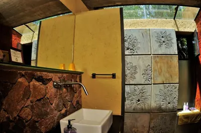 a bathroom with a sink and a wall with a window at Cuatrovientos Hostería in San Javier