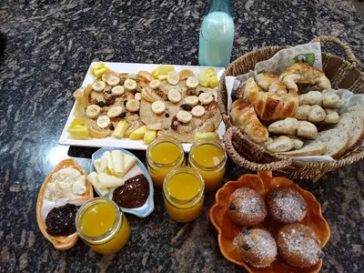 a table with a tray of breakfast foods and orange juice at 7 esencias in Villa Yacanto