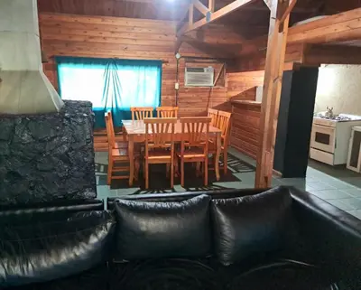 a living room with a couch and a table and chairs at Cabañas UN LUGAR in Villa General Belgrano