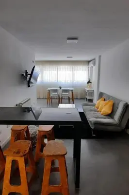 a living room with a couch and a table and stools at Departamento Centro Artístico Manzana Jesuítica in Cordoba