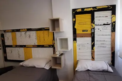 a bedroom with two beds and a wall with yellow panels at Departamento Centro Artístico Manzana Jesuítica in Cordoba