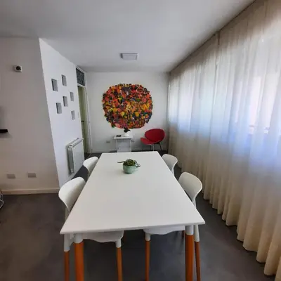 a white table and chairs in a room with a wreath at Departamento Centro Artístico Manzana Jesuítica in Cordoba