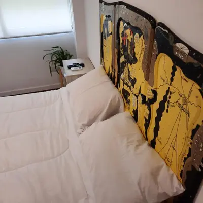 a bed in a room with a wall at Departamento Centro Artístico Manzana Jesuítica in Cordoba
