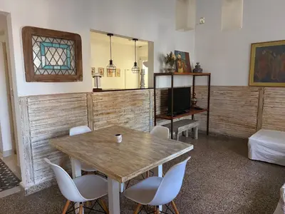 a room with a table and chairs and a television at Elportal in Alta Gracia