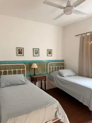 a bedroom with two beds and a ceiling fan at Elportal in Alta Gracia
