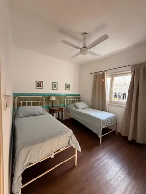 a bedroom with two beds and a ceiling fan at Elportal in Alta Gracia