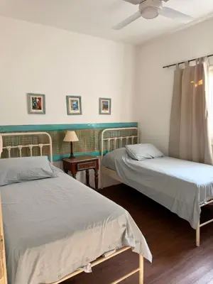 a bedroom with two beds and a window with a fan at Elportal in Alta Gracia