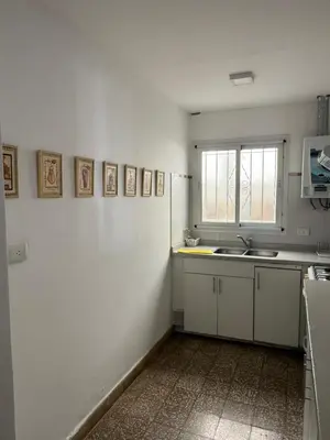 a kitchen with white walls and a sink and a window at Elportal in Alta Gracia