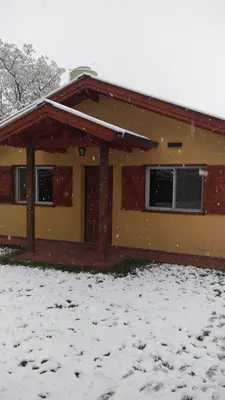 a house with snow on the ground in front of it at La Casita de Onha in Villa Ciudad Parque