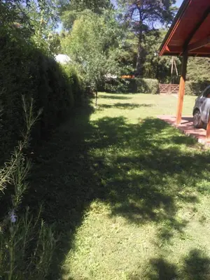 a yard with a shadow of a tree on the grass at La Casita de Onha in Villa Ciudad Parque