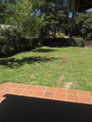 a field of grass with a brick walkway in a yard at La Casita de Onha in Villa Ciudad Parque