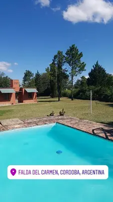 a blue swimming pool with a dog in a field at Casa de campo in Santa María