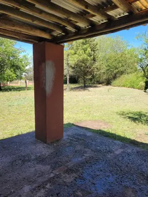 a column under a wooden roof in a field at Casa de campo in Santa María
