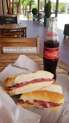 a sandwich and a bottle of coke on a table at Casa de campo in Santa María