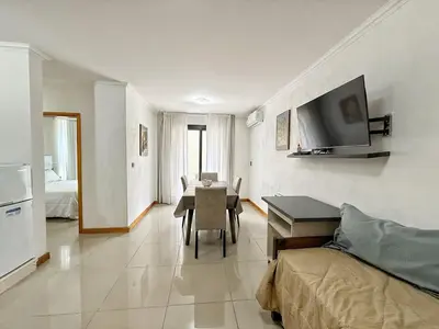 a living room with a dining room table and a television at Constantino V in Villa Carlos Paz