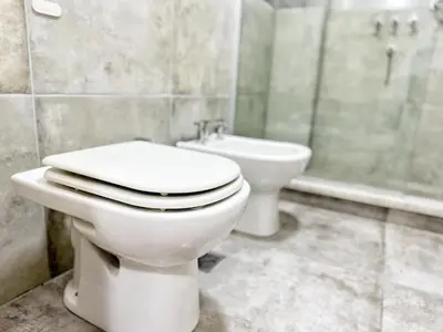 a bathroom with a toilet and a sink and a tub at Constantino V in Villa Carlos Paz