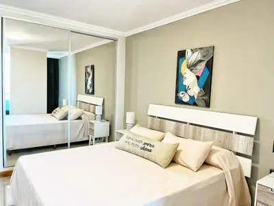 a bedroom with two beds and a mirror at Constantino V in Villa Carlos Paz
