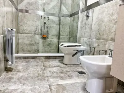 a bathroom with a toilet and a shower and a sink at Constantino V in Villa Carlos Paz