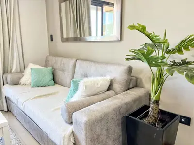 a living room with a couch and a potted plant at Constantino V in Villa Carlos Paz