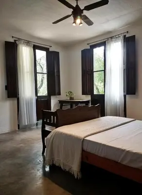 a bedroom with a bed and a ceiling fan at Aloja Merlo - Conectá con la naturaleza en un ambiente único in Merlo