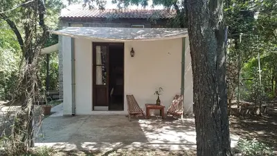 a small white house with two chairs and a table at Aloja Merlo - Conectá con la naturaleza en un ambiente único in Merlo