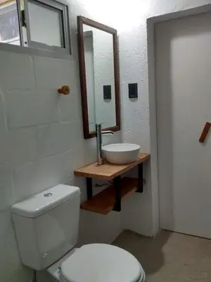 a bathroom with a toilet and a sink and a mirror at Aloja Merlo - Conectá con la naturaleza en un ambiente único in Merlo