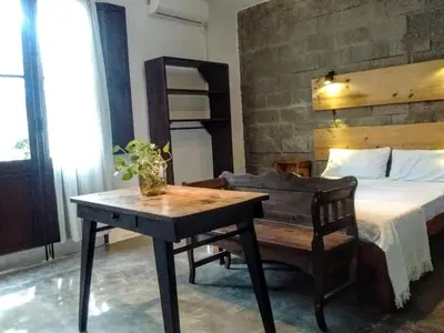 a bedroom with a bed and a table and a desk at Aloja Merlo - Conectá con la naturaleza en un ambiente único in Merlo