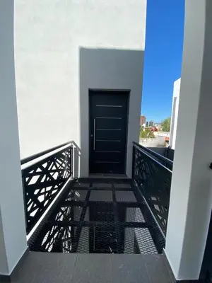 a walkway leading to a black door on a building at ALEM LANE in Villa Carlos Paz