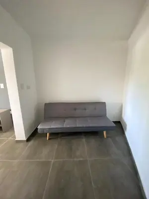 a blue couch sitting in a room with a wall at ALEM LANE in Villa Carlos Paz