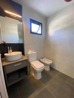 a bathroom with a white toilet and a sink at ALEM LANE in Villa Carlos Paz