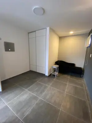 a living room with a black couch and a tile floor at ALEM LANE in Villa Carlos Paz