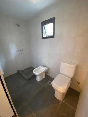 a white bathroom with a toilet and a sink at ALEM LANE in Villa Carlos Paz