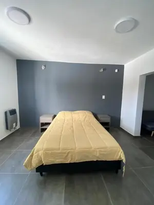 a bedroom with a bed with a blue wall at ALEM LANE in Villa Carlos Paz