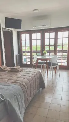 a bedroom with a table and a bed and a table and chairs at Depto Las Heras in Villa Carlos Paz