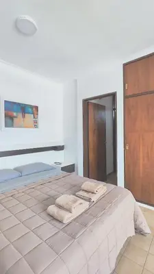 a bedroom with a large bed with towels on it at Depto Las Heras in Villa Carlos Paz