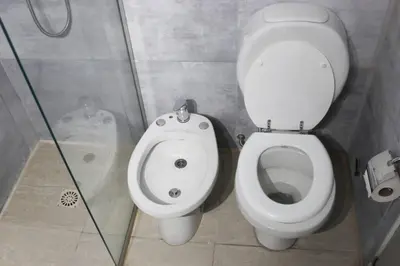a bathroom with a toilet and a glass shower at Nuevo Abrojal: departamento en Barrio Güemes in Cordoba