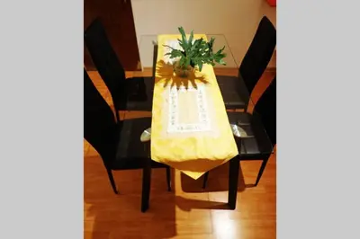 a table with a yellow table cloth and a flower on it at Nuevo Abrojal: departamento en Barrio Güemes in Cordoba