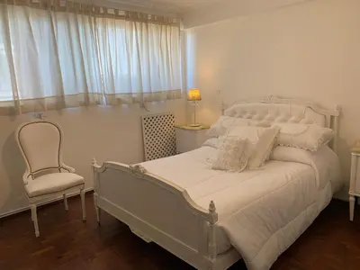 a bedroom with a white bed and a chair at Mirador de Plaza España in Cordoba
