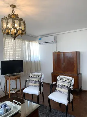 a living room with two chairs and a tv at Mirador de Plaza España in Cordoba