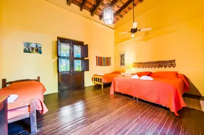 a bedroom with two beds and a wooden floor at Posada El Pucara in San Javier